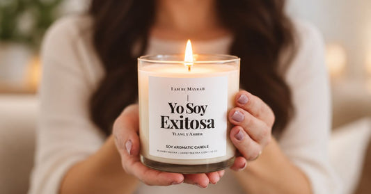 Manos sosteniendo la vela de soja Yo Soy Exitosa encendida, de I AM BY MAYRA
